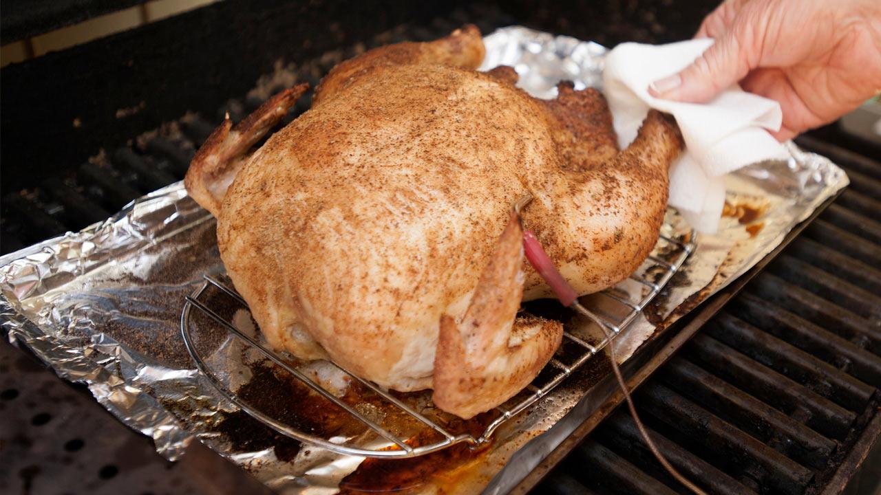 A barbecued chicken being temperature tested for safety
