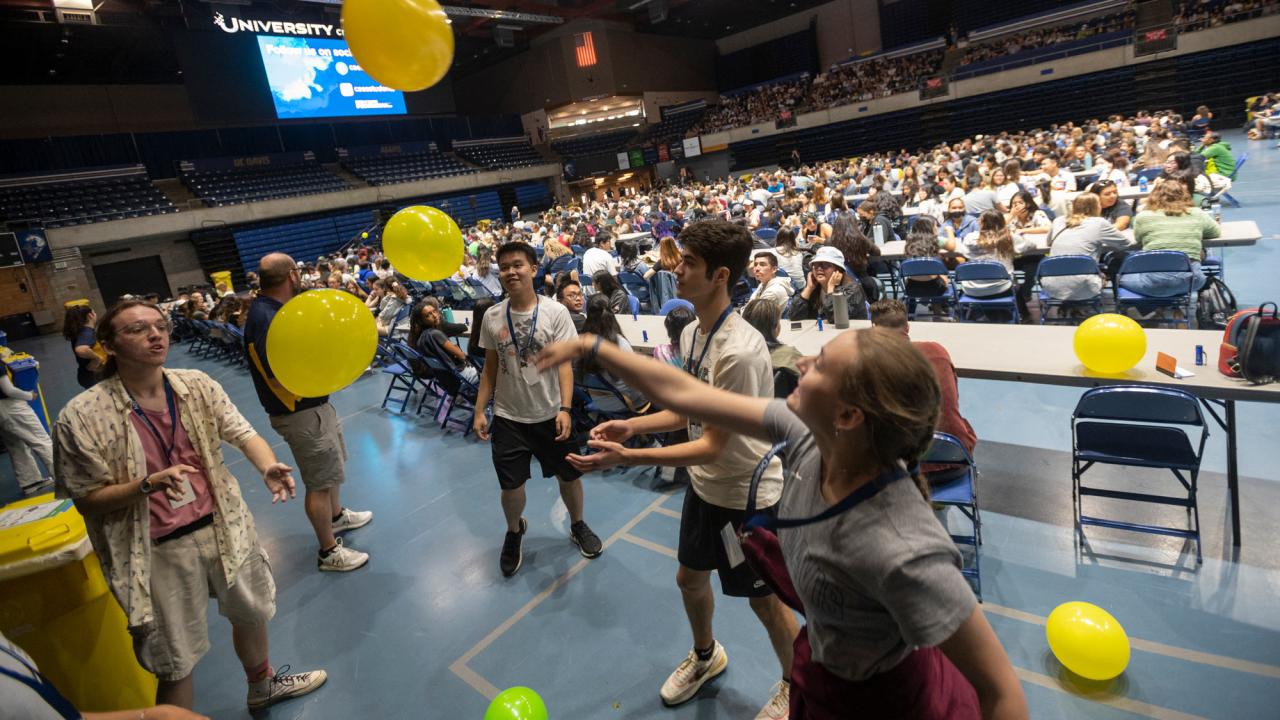 New students play with balloons at mass orientation event
