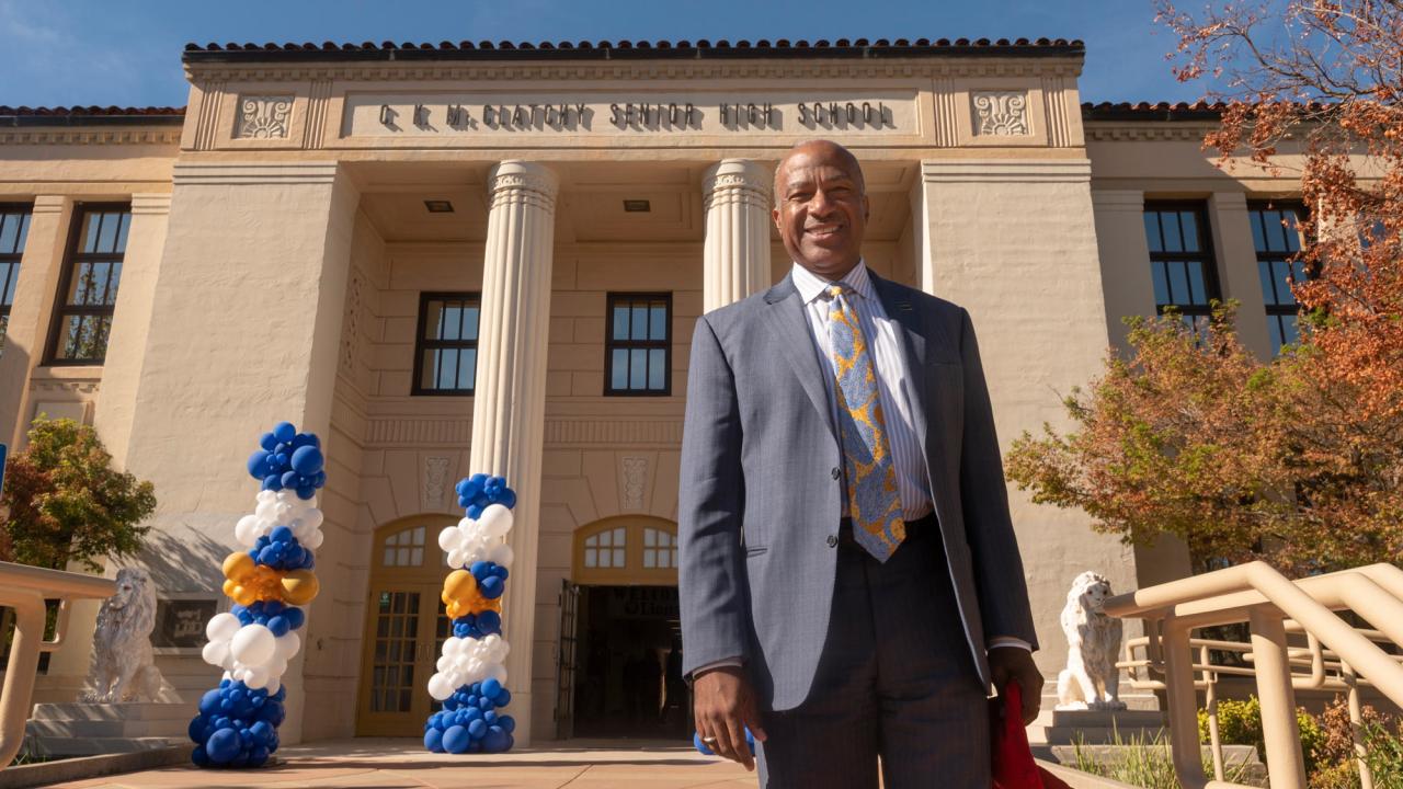Chancellor Gary S. Map, UC Davis, in suit, in front of C.K. McClatchy High School