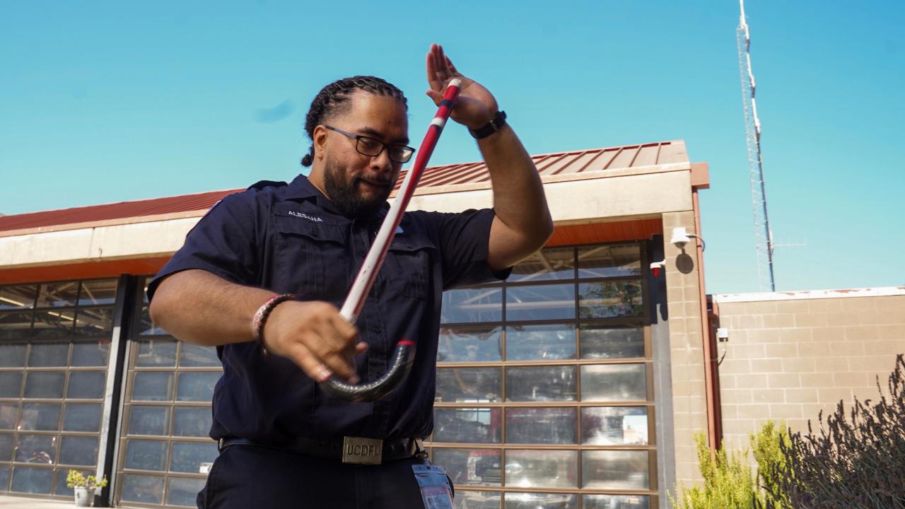 Abiel Malepeai with his fraternity cane outside the UC Davis Fire Department.