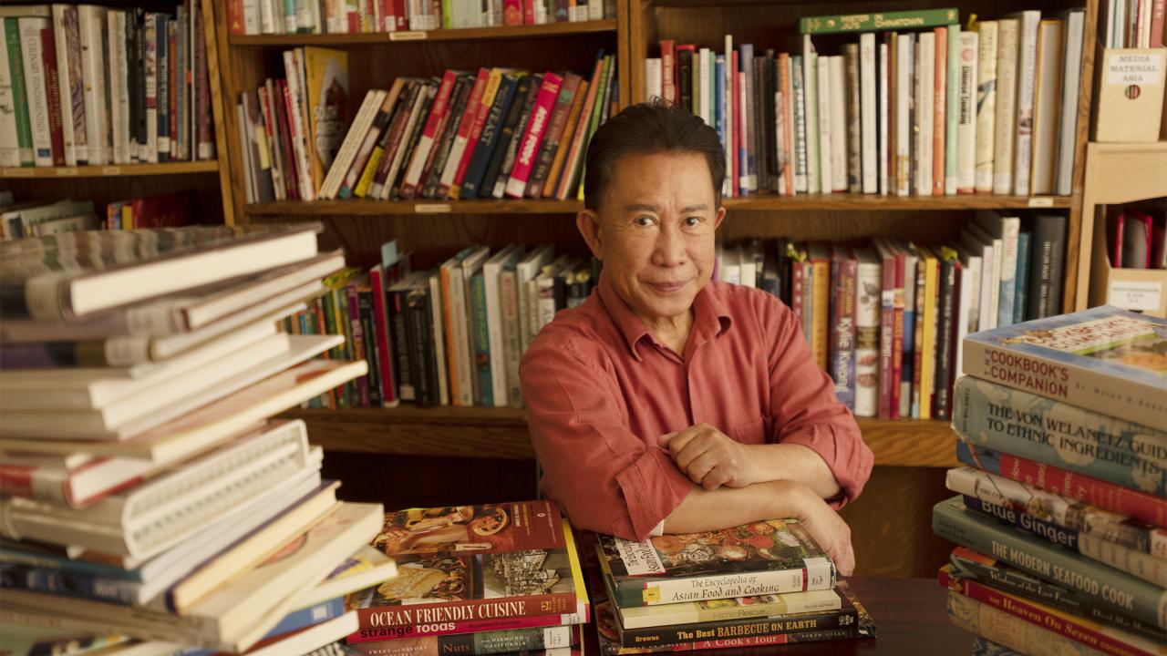Chef Martin Yan sits among cookbooks donated to UC Davis