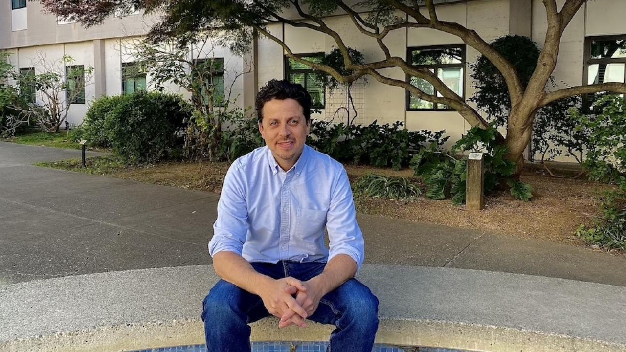 man in blue clothing sitting at UC Davis outdoor spot