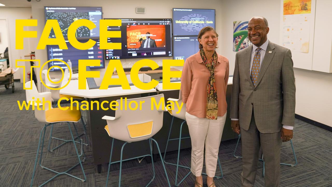 Pam Ronald and Gary S. May pose for photo in front of screens, with "Face to Face With Chancellor May" text superimposed onto the photo.