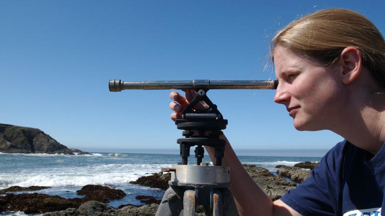 A female researcher surveys the coastline near bodega bay