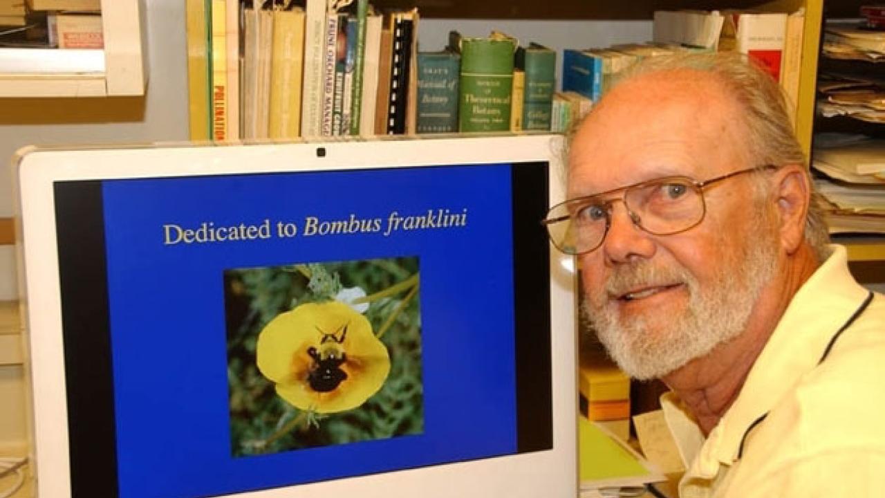 Robbin Thorp poses next to computer screen showing a Franklin’s bumblebee.