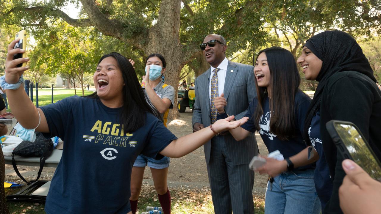 Students take selfies with Chancellor Gary S. May.
