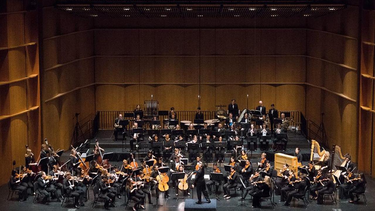 symphony performing on darkened stage