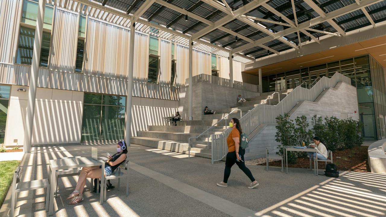Students sit and study outside the Teaching and Learning Complex.