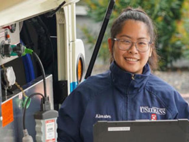 Woman in Unitrans jacket, at her workplace (bus manufacturer)