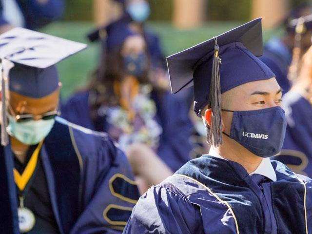 A student attending a masked graduation ceremony