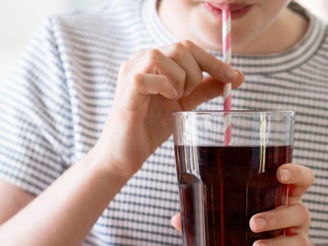 A child drinks a soda through a straw