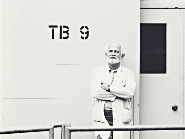 An artist stands outside the door of the TB-9 art building at UC Davis