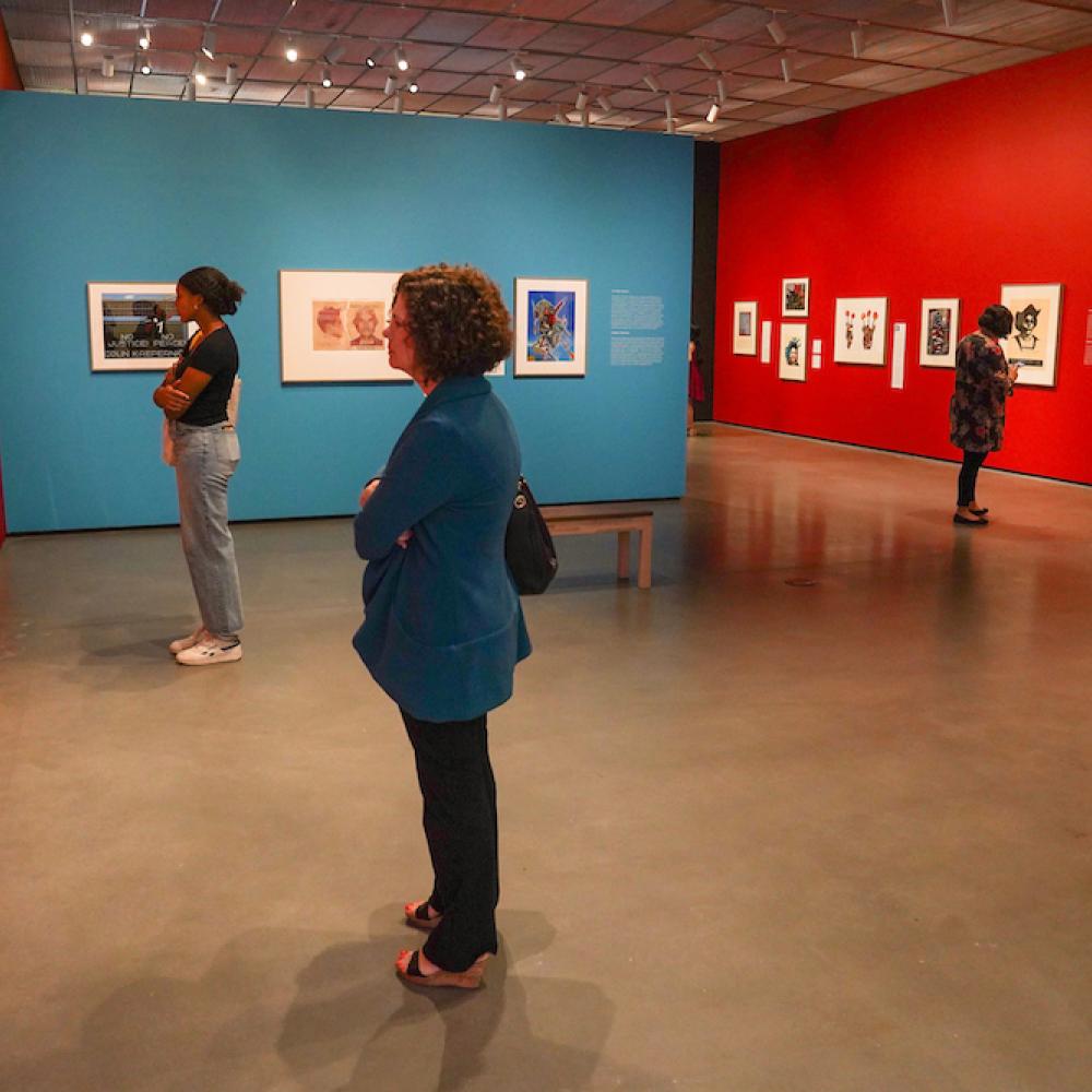 people observe art on walls in an art museum at UC Davis