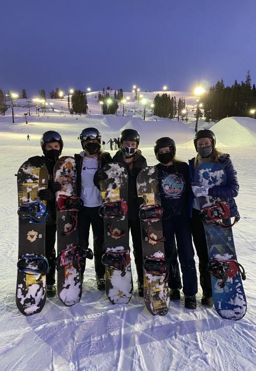 Five People Posing With Snowboards