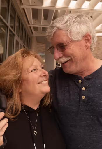A smiling couple gazing into each other’s eyes, enjoying a joyful moment together.