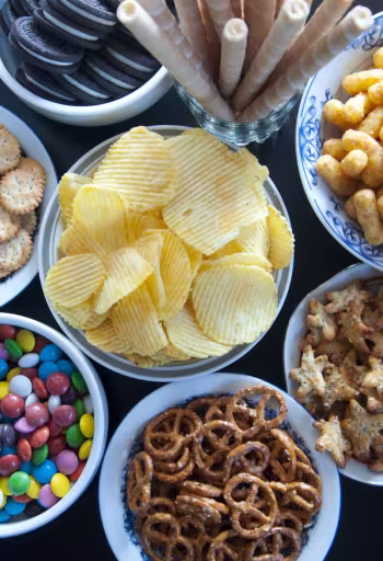 In this episode of Unfold, we uncover the science and debate behind processed and ultra-processed foods. Shown here are eight bowls with various processed and ultra-processed foods, including chips, pretzels and candies.(Getty)
