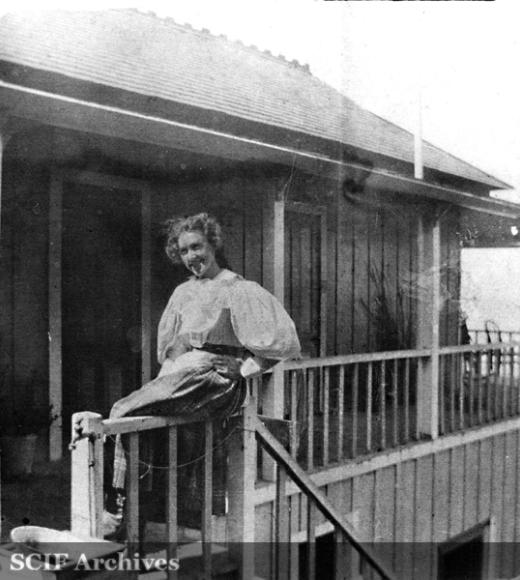 Blanche Trask sitting on her balcony porch smiling