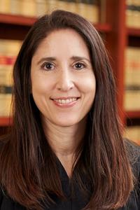 A closeup photo of Justice Patricia Guerrero against a backdrop of law books