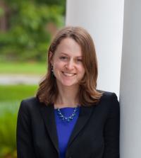 Woman in dark suit and blue blouse outdoors at law school 