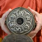 A monk holds a votive tablet at UC Davis.