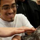 Male student holds a seastar as someone touches it