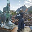 Workers remove a statue.