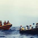 Wooden boats carrying migrants at sea, from book cover.