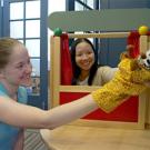 Photo: Two women playing with puppets.
