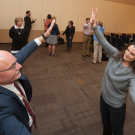 Two people standing, "mirroring" each others movements.