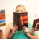 Woman reading three books with four hands