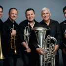 Five men, each holding a brass instrument