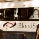 Chancellor chats with blood donors, in front of bloodmobile.