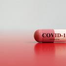 An Rx capsule labeled "COVID-19 Coronavirus"