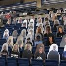 Cardboard cutouts of fans in stands.