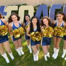 Seven members of the Dance Team in front of #GoAgs sign