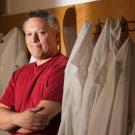 Man standing a rack of lab coats