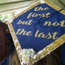A graduation cap says "the first but not the last"