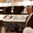 Chancellor Gary S. May chats with blood drive representatives, with bloodmobile in background, on the Quad.