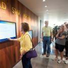 People look at a TV screen displaying the Golden Memory Book.