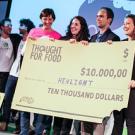 Photo: Four people holding a big "check" for $10,000 while posing for a picture.