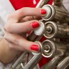A close-up photo of the hands playing an instrument.