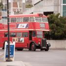 Red, vintage double-decker bus enters Memorial Union depot.