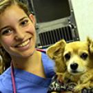 Photo: Vet student Rachel Ferris in scrubs, holding a dog
