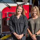 New firefighters Nicole McCurry and Meggie Elledge in front of firetruck