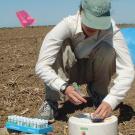 Photo: woman measuring emissions from soil in field