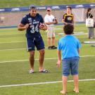 Football player in a drill with a boy.