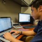 Photo: Student Patrick Khamnrongsad works on laptop, with Inclusive Access digital course content