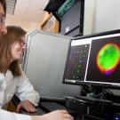 Scientists looking at microscope images on screen