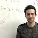Mathematician Roger Casals in front of a whiteboard.