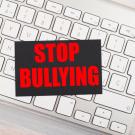 "Stop Bullying" message atop keyboard, in stock photo